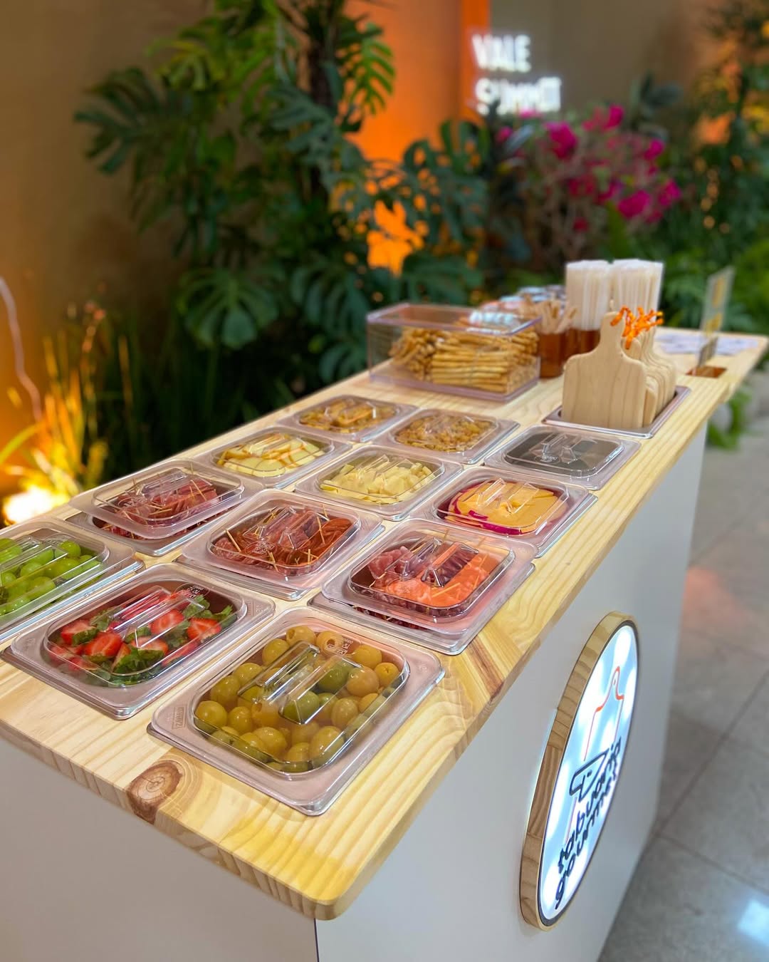 Estação gastronômica com frutas, queijos e charcutaria